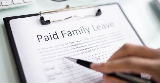 employee signing paid family leave papers